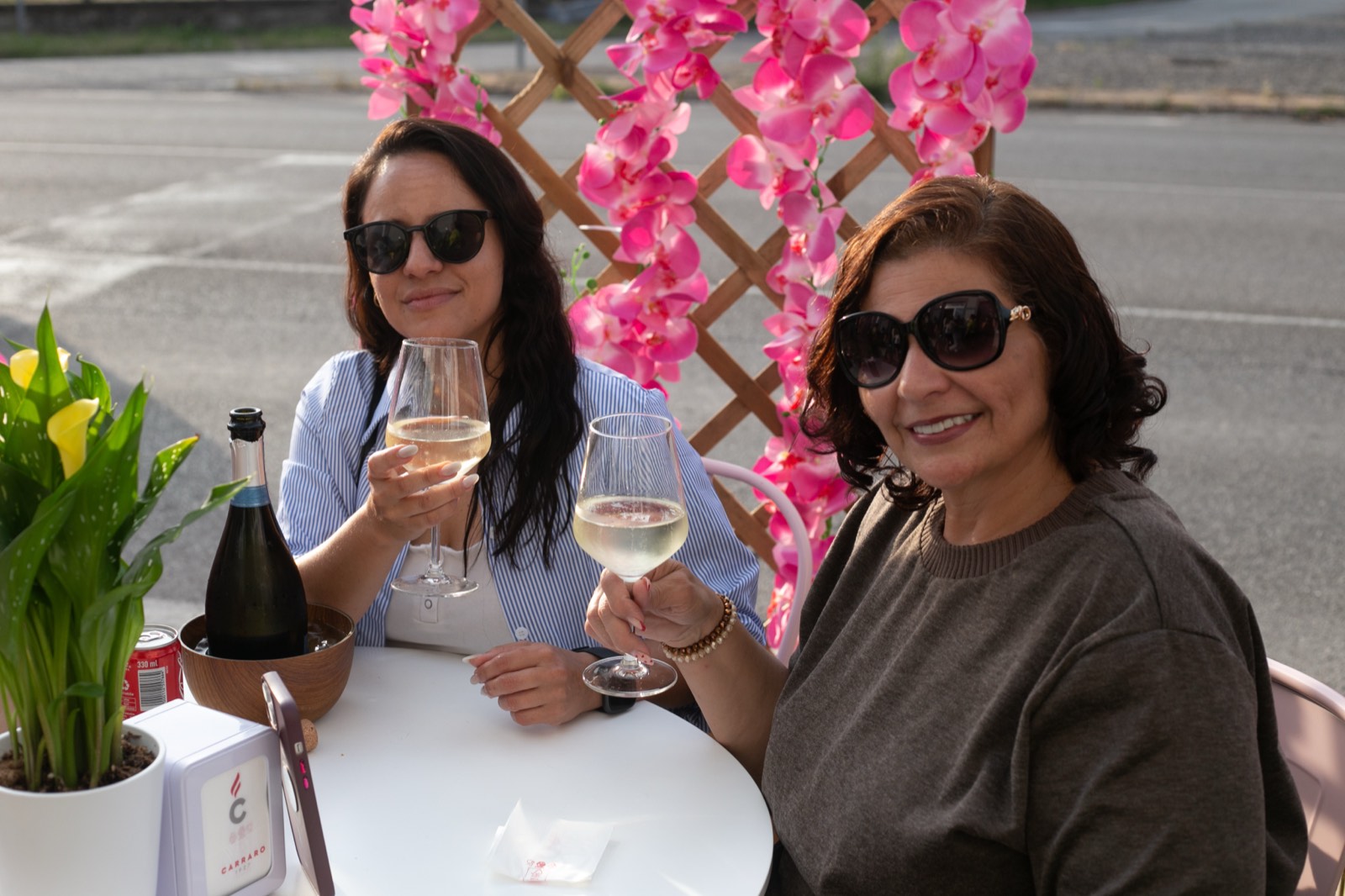 Due clienti brindano con il prosecco ai tavolini