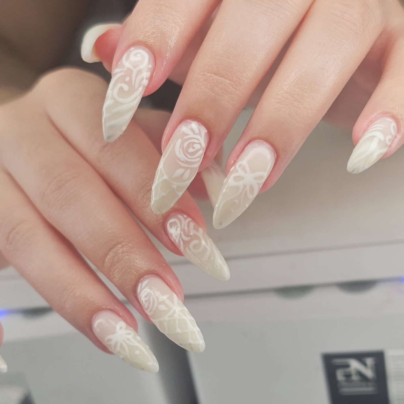 Nail art bianca con merletti e rose dipinte a mano