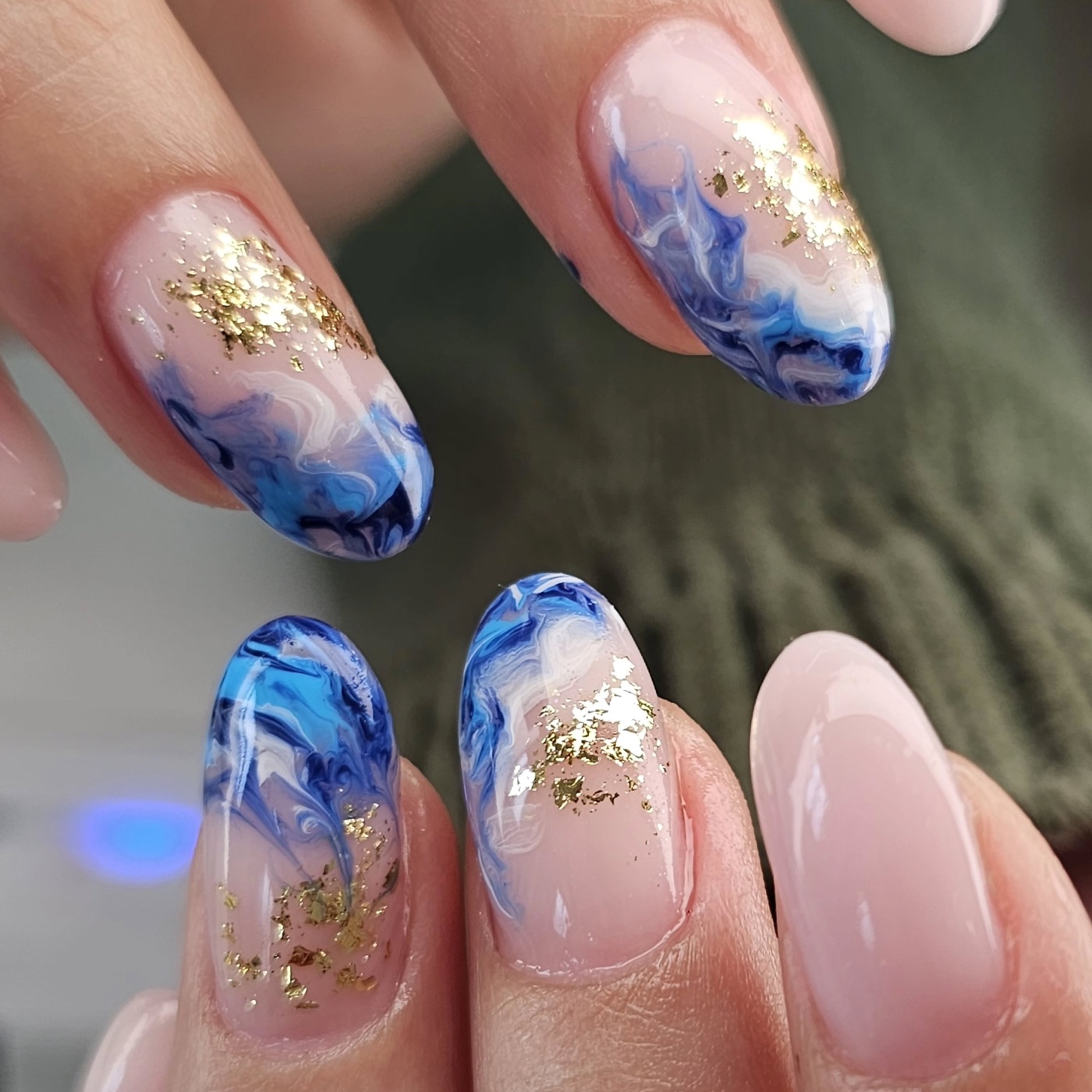 Nail art blu marmorizzata con foglia oro